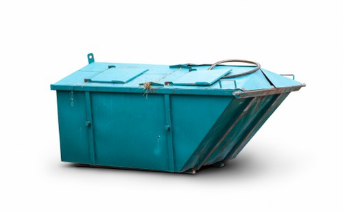 A large, rectangular industrial skip in a vibrant turquoise colour, positioned outdoors on a paved surface, with both front and side views visible. The skip's textured metal surface features vertical reinforcing ribs and a slightly weathered finish, with scratches and minor dents indicating previous use. The lid on top is slightly ajar, revealing a glimpse of the interior, which appears empty. The front of the skip has a sloped panel near the bottom for easier loading. Positioned on the right side of the image, a black hydraulic lifting cable extends from the top of the skip, suggesting it is designed for mechanical lifting onto waste collection vehicles. The background is plain and white, isolating the skip for clear visibility. This image aligns with waste management services offered by Commercial Waste Teddington, suitable for commercial rubbish removal across the local area, including Teddington and nearby TW postcodes.