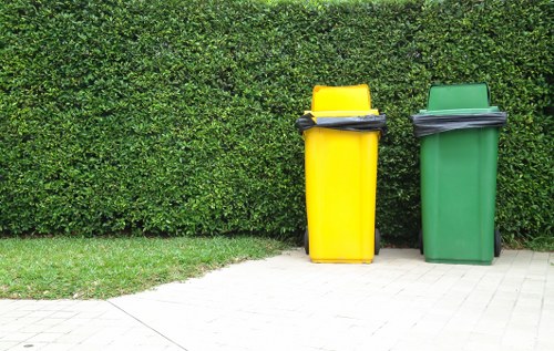 Workers handling waste containers with PPE on site